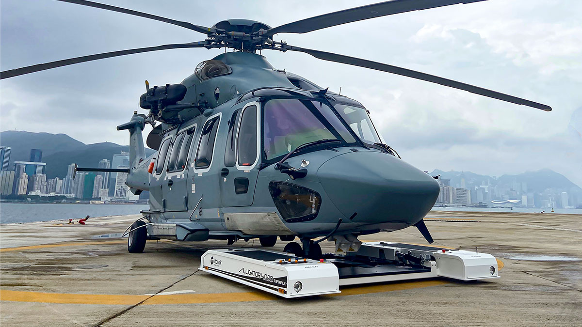 Mototok Alligator tows an Airbus Helicopter with mounted parts underneath the fuselage